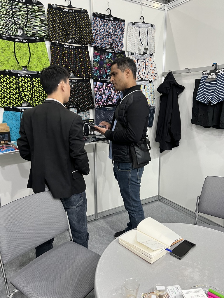 Underwear samples with Unitex branding on the booth wall