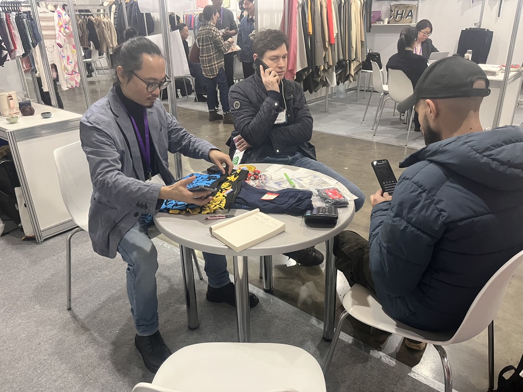 Negotiating samples and prices with a buyer at the Unitex booth